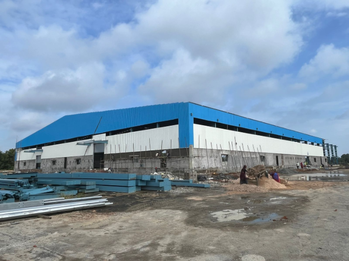 Exterior view of a massive 165,000 sq ft PEB warehouse near Surat, designed and executed by our structural consultancy for heavy industrial use - detailed peb design at shreeses