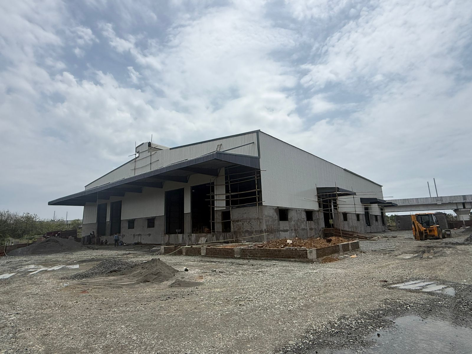 On-site construction of a custom-designed Pre-Engineered Building warehouse with industrial wall cladding by SHREESES, leading PEB consultants.